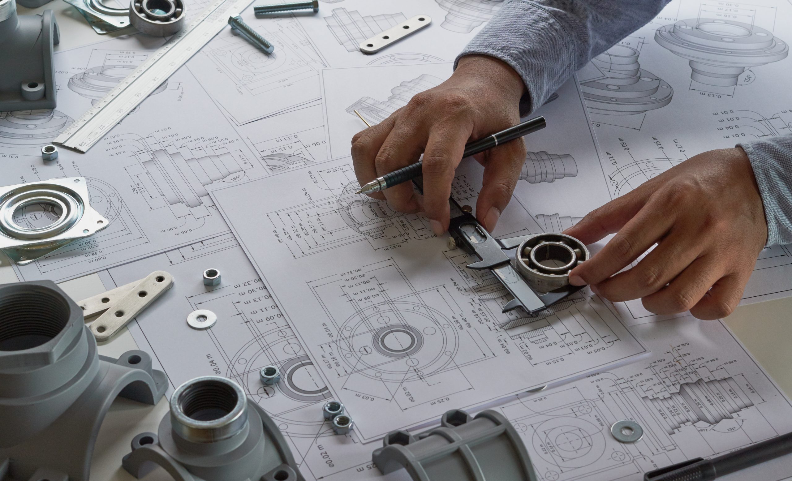 Engineer technician designing drawings mechanical parts engineering Engine.manufacturing factory Industry Industrial work project blueprints measuring bearings caliper tools